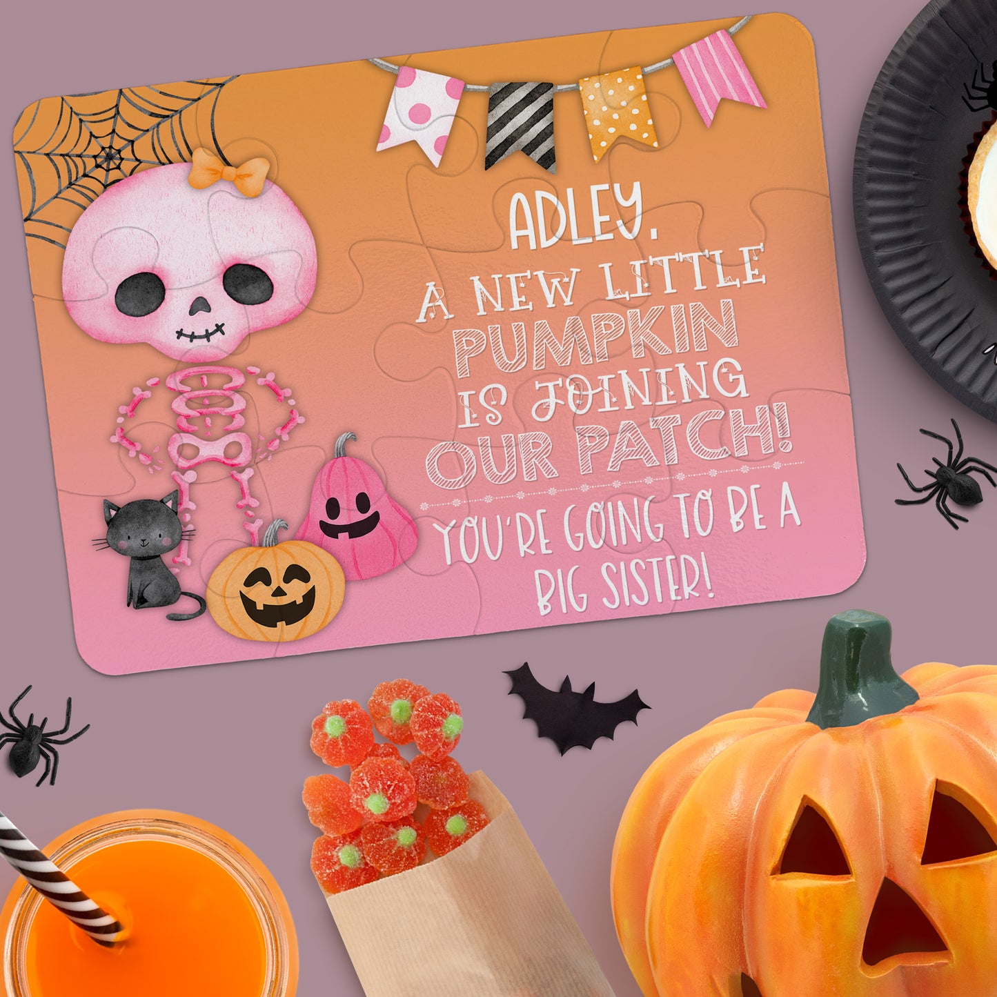 A Halloween-themed puzzle announces a pregnancy, with skeleton and pumpkin illustrations and the message: "Adley, a new little pumpkin is joining our patch! You're going to be a big sister!.