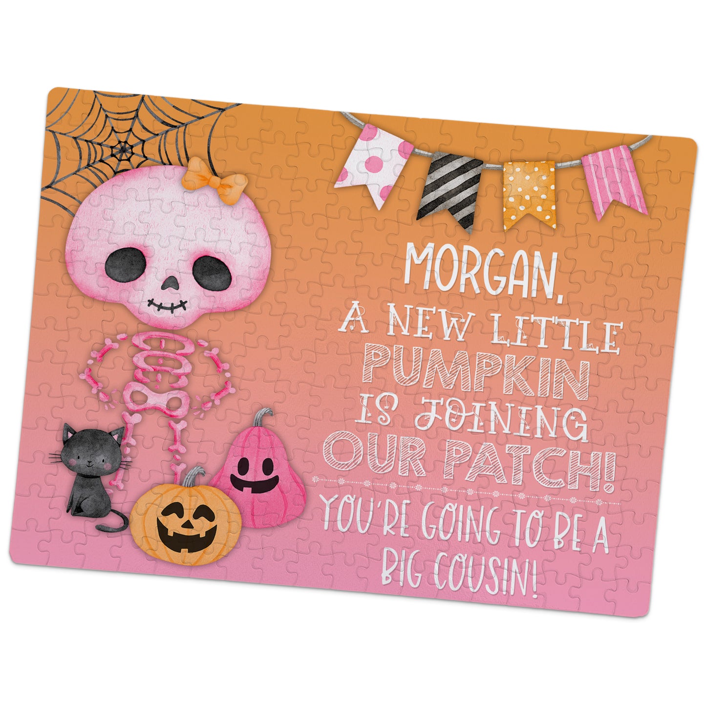 A Halloween-themed jigsaw puzzle announces a new baby joining the family, with a pink skeleton, pumpkins, a cat, and a message that Morgan will be a big cousin.