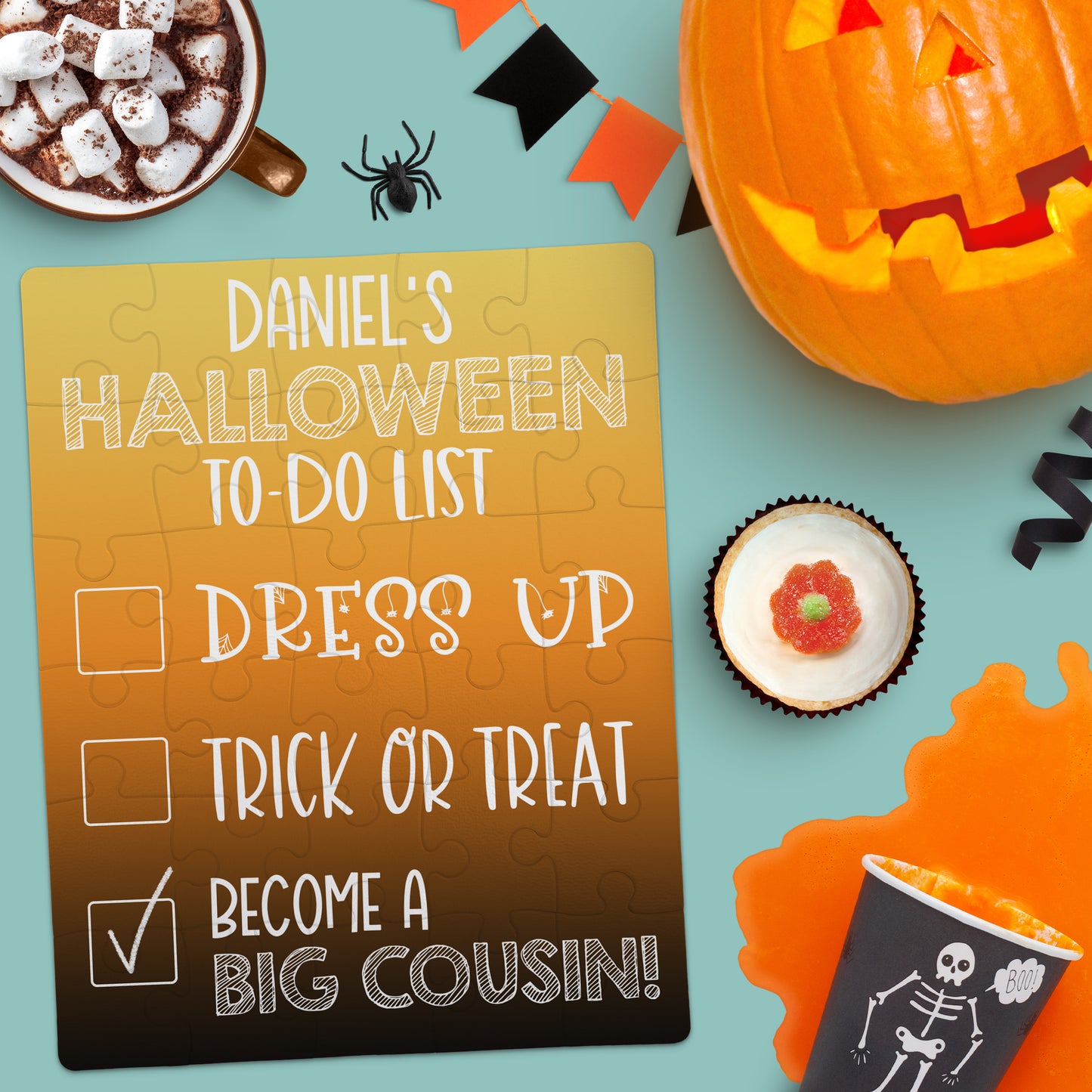 A Halloween-themed flat lay with a checklist reading "Daniel's Halloween To-Do List: Dress Up, Trick or Treat, Become a Big Cousin!" surrounded by festive treats and decorations.