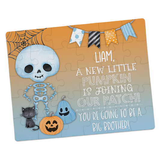 A Halloween-themed puzzle with a skeleton, pumpkins, a cat, and a banner, announcing "Liam, a new little pumpkin is joining our patch! You’re going to be a big brother!.