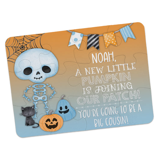 Skeleton and pumpkins puzzle with text: "Noah, a new little pumpkin is joining our patch! You're going to be a big cousin!" Banner and spiderweb decorations on top.