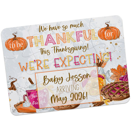 A Thanksgiving-themed card with pumpkins, pie, leaves, and food, announcing a pregnancy: "We're expecting! Baby Jesson arriving May 2026!.