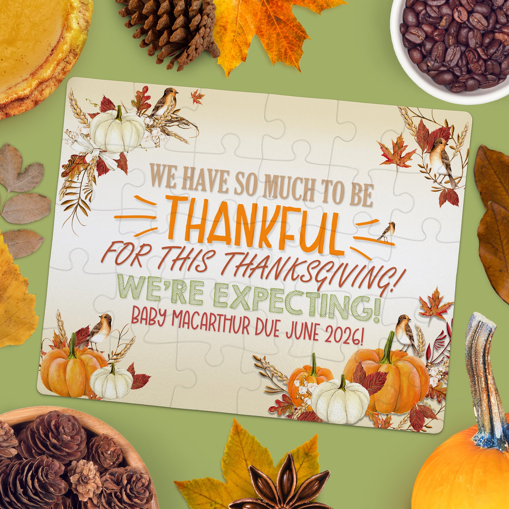 A puzzle on a table reads, "We have so much to be thankful for this Thanksgiving! We're expecting! Baby MacArthur due June 2026!" surrounded by autumn-themed items.