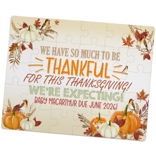 A decorative puzzle with pumpkins, flowers, and birds displays the message: "We're expecting! Baby Macarthur due June 2026!" above an autumn-themed background.
